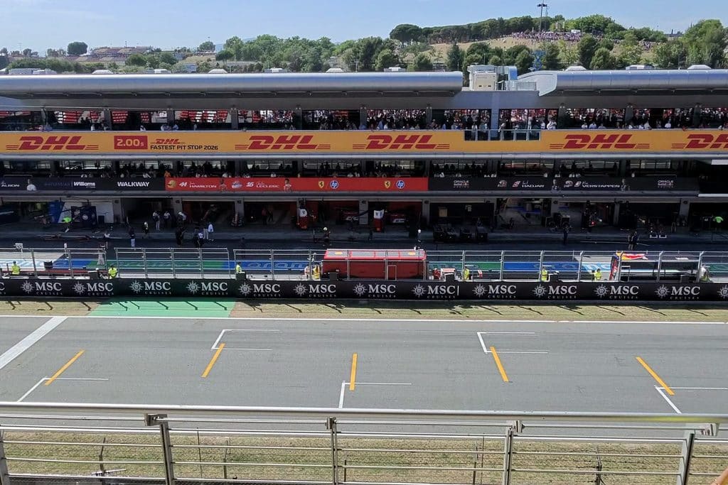 Formula 1 Grandstand The Barcelona circuit main straight, pit building and garages viewed across the safety fence from a grandstand.