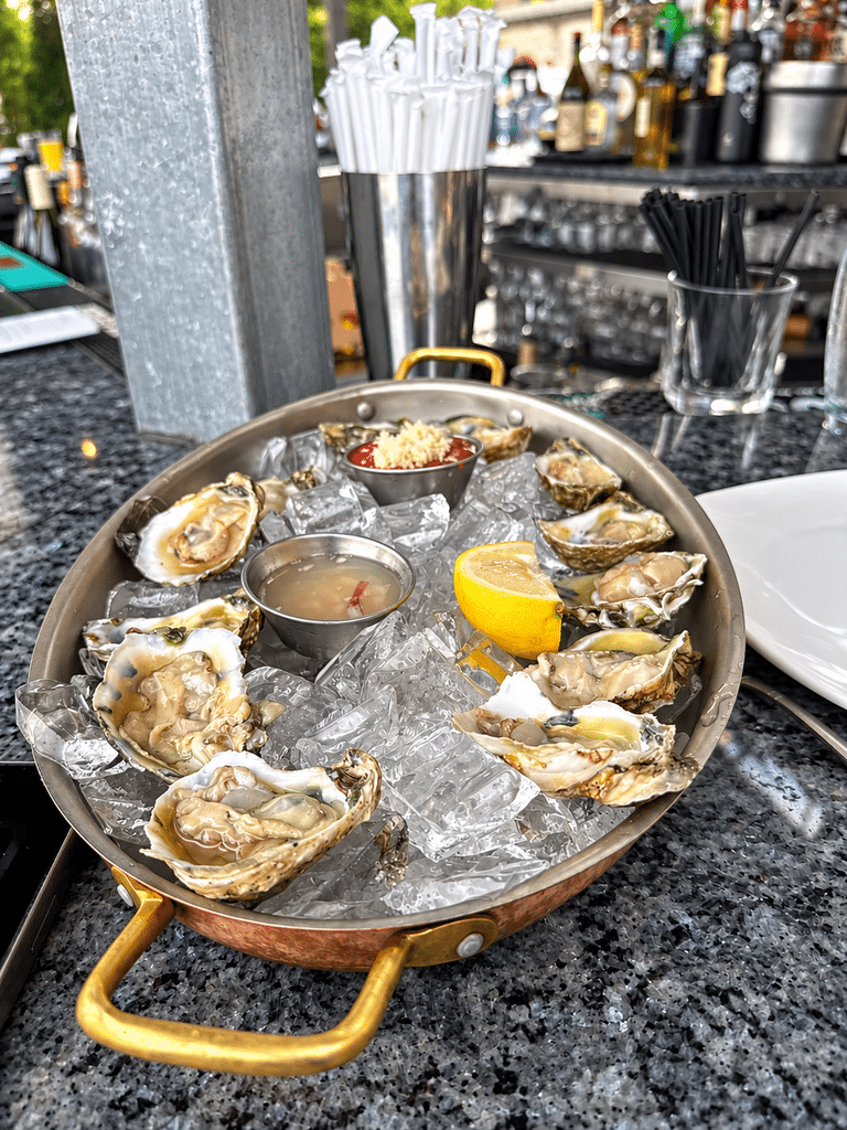 Blu Pointe Review Fresh oysters served over ice in a copper platter at Blu Pointe’s outdoor bar